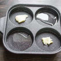 В каждую секцию сковороды кладем небольшой кусочек сливочного масла. В каждую секцию сковороды кладем небольшой кусочек сливочного масла.