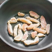В разогретое масло бросаем кусочки курицы в крахмале, быстро обжариваем до золотистого цвета с двух сторон.
