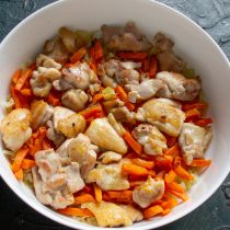 На лук с морковкой выкладываем обжаренные кусочки курицы.