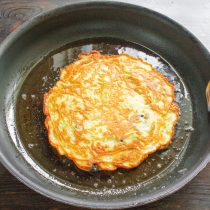 Широкой лопаткой переворачиваем блин.