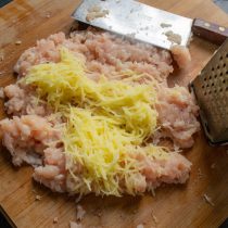 На мелкой тёрке натираем сырой картофель, добавляем к куриному фаршу.