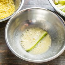 В отдельную миску разбиваем куриное яйцо, насыпаем щепотку соли, наливаем холодное молоко.