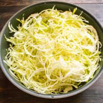 Шинкуем капусту очень тонкими полосками, лучше использовать овощерезку.