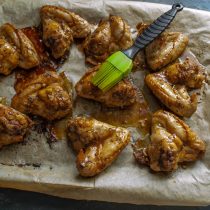 Смазываем крылышки медовой глазурью с помощью силиконовой кисточки.