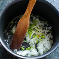 Добавляем сливочное масло, нарезанный лук и сельдерей.