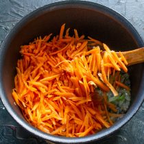 Добавляем тертую морковь к обжаренным овощам.