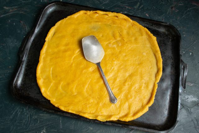 Раскатываем тесто прямо на противне. Раскатываем тесто прямо на противне.