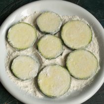 Панируем ломтики кабачка в пшеничной муке. Панируем ломтики кабачка в пшеничной муке.