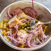 Добавляем каперсы к остальным ингредиентам салата.