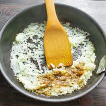 В разогретое масло бросаем нарезанный лук, посыпаем щепоткой соли.