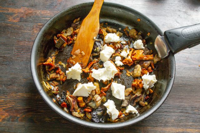 Поджаренные грибы остужаем, добавляем мягкую брынзу.