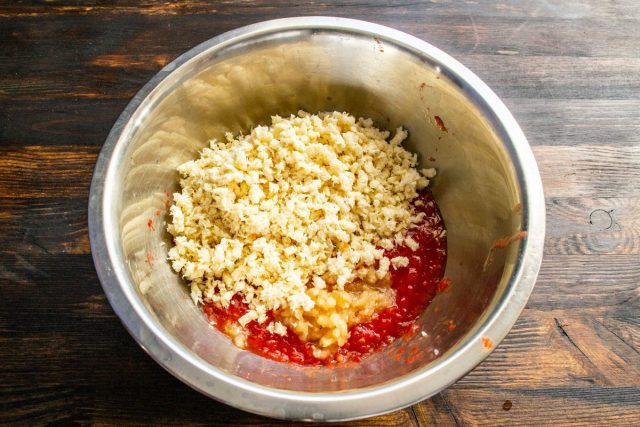 Соединяем ингредиенты: добавляем измельчённый хрен к томатно-чесночной массе, насыпаем соль и перемешиваем ложкой.