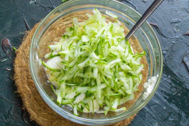 Кладем натёртые огурцы в соус.