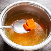 Наливаем в кастрюлю 500 мл бульона. Вареную морковь нарезаем мелкими кубиками, бросаем в бульон.