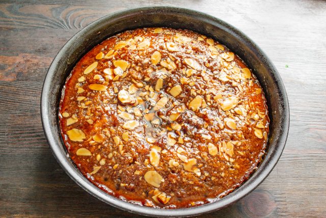 Оставляем манник пропитываться на несколько часов. Накрываем остывшую форму пищевой пленкой, чтобы сохранить влажность верха, затем нарезаем и подаем.