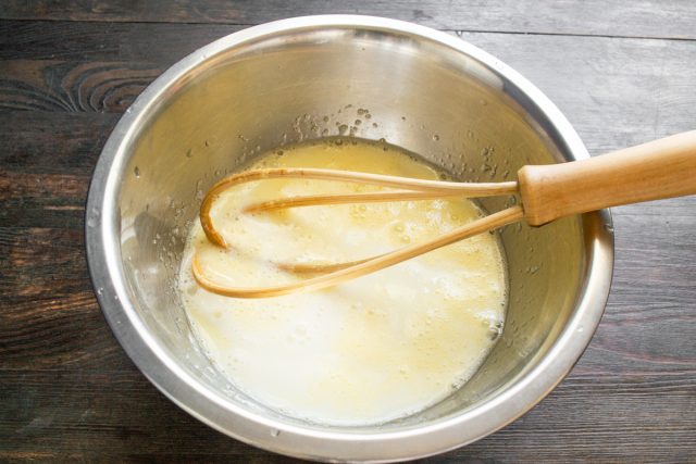 Вливаем во взбитую яичную смесь молоко комнатной температуры. Заранее достаем продукты из холодильника, чтобы они согрелись перед приготовлением теста.