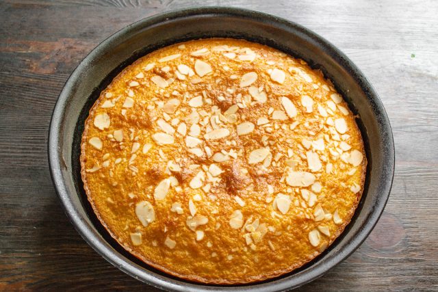 Выпекаем манник при 170 градусах. Проверяем готовность нажатием пальца: если мякиш пружинит — достаем, если проваливается — допекаем еще несколько минут.