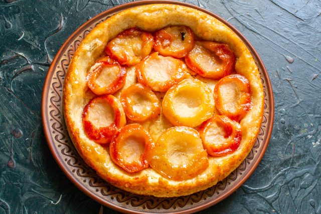 Прикладываем к сковороде большую тарелку и быстро переворачиваем пирог. Если все сделано верно, он получится красивым, румяным и сохранит свою форму.