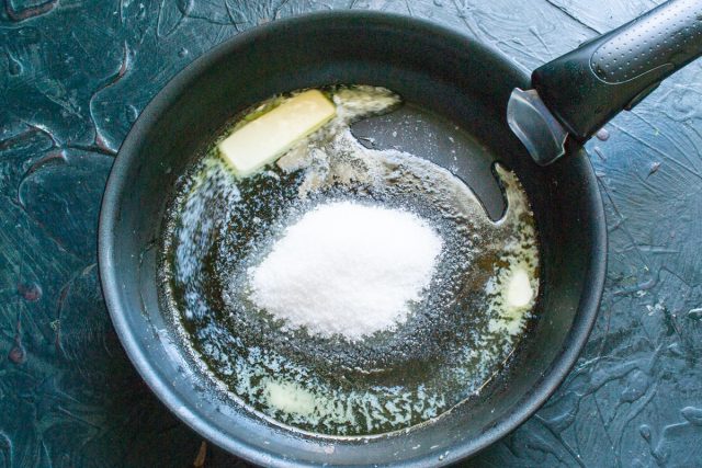 Кладем в широкую сковороду сливочное масло, насыпаем сахарный песок. Нагреваем на небольшом огне, помешивая, пока сахар полностью не растает в масле.