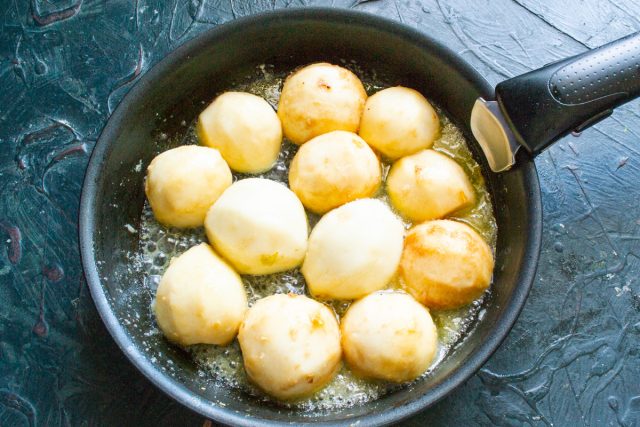 Выкладываем очищенные половинки груш срезом вниз в кипящую карамель. Убавляем нагрев плиты до минимального значения, чтобы фрукты томились в сиропе.