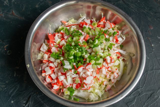 Мелко рубим ножом перья зеленого лука и высыпаем их к остальным компонентам салата. При желании заменяем лук свежим укропом для более мягкого аромата Мелко рубим ножом перья зеленого лука и высыпаем их к остальным компонентам салата. При желании заменяем лук свежим укропом для более мягкого аромата