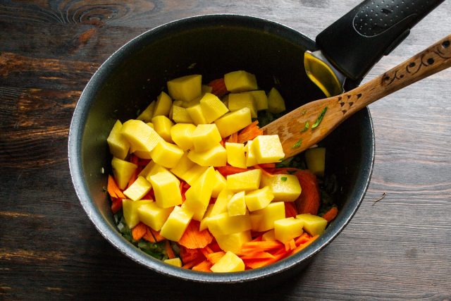 Картофель нарезаем аккуратными кубиками размером около 1 см. Отправляем его в кастрюлю следом за морковью