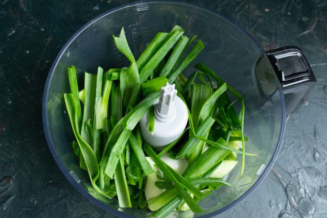 Мелко шинкуем промытый зеленый лук вместе с белыми головками ножом. Перекладываем измельченную луковую массу в чашу блендера. Мелко шинкуем промытый зеленый лук вместе с белыми головками ножом. Перекладываем измельченную луковую массу в чашу блендера.