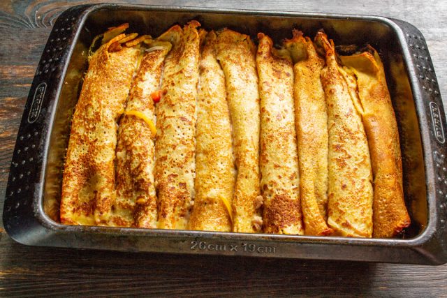 Накрываем форму фольгой и отправляем в духовку на 20 минут при 180 градусах. Запекаем до готовности, чтобы блины пропитались соусом и стали нежными.