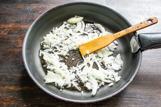 Нарезаем очищенный репчатый лук мелкими кубиками. Обжариваем нарезку на растительном масле в сковороде в течение пяти минут до прозрачности и мягкости.