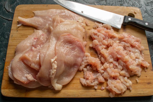 Нарезаем куриное филе порционными ломтиками толщиной около сантиметра для отбивных. Собираем все мясные обрезки и перемалываем их в фарш для начинки.