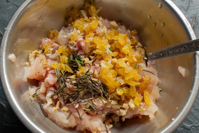 Замачиваем изюм в кипятке на 10 минут, промываем, обсушиваем и мелко режем. Обрываем листья розмарина с веточек, измельчаем и добавляем к начинке.