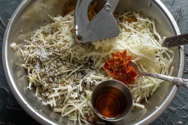 Приправляем начинку морской солью, черным перцем и смесью прованских трав. Вливаем порцию коньяка и добавляем ложку острой аджики для пикантности.