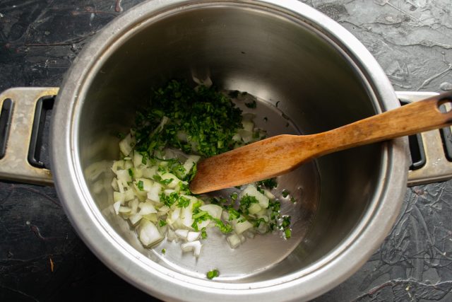 Измельчаем репчатый лук, чеснок и зелень петрушки. Обжариваем овощи в кастрюле с толстым дном на растительном масле до появления яркого аромата. Измельчаем репчатый лук, чеснок и зелень петрушки. Обжариваем овощи в кастрюле с толстым дном на растительном масле до появления яркого аромата.