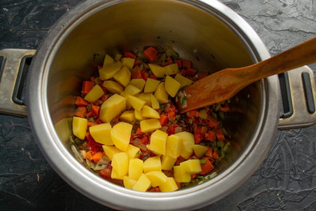 Очищаем клубни картофеля от кожуры и нарезаем их крупными одинаковыми кубиками. Перекладываем картофельную нарезку в кастрюлю к томатной зажарке. Очищаем клубни картофеля от кожуры и нарезаем их крупными одинаковыми кубиками. Перекладываем картофельную нарезку в кастрюлю к томатной зажарке.