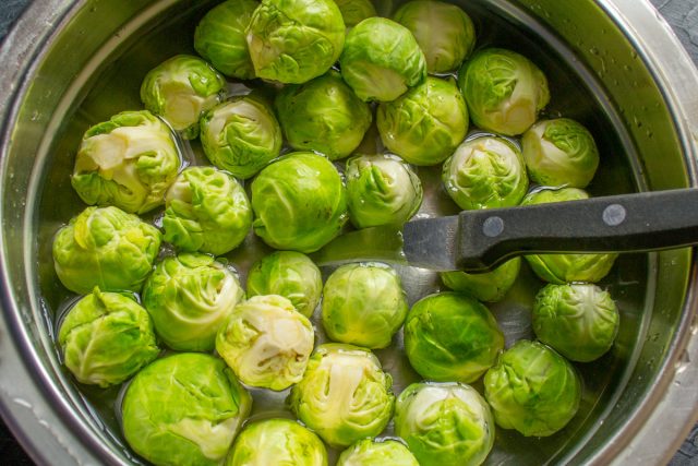 Срезаем жесткие кочерыжки у брюссельской капусты и аккуратно снимаем верхние листья. Промываем кочанчики водой, крупные экземпляры разрезаем пополам. Срезаем жесткие кочерыжки у брюссельской капусты и аккуратно снимаем верхние листья. Промываем кочанчики водой, крупные экземпляры разрезаем пополам.