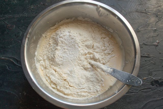 Всыпаем просеянную пшеничную муку в миску с жидкими ингредиентами. Начинаем замешивать блинное тесто венчиком, стараясь максимально разбить все комочки. Всыпаем просеянную пшеничную муку в миску с жидкими ингредиентами. Начинаем замешивать блинное тесто венчиком, стараясь максимально разбить все комочки.