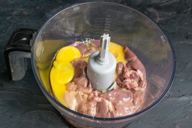 Разбиваем в чашу к печени два крупных куриных яйца. Если яйца мелкие, дополнительно вливаем пару ложек молока или сливок для нужной консистенции.