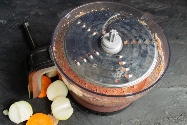 Очищаем лук и морковь, нарезаем крупно. Устанавливаем насадку-терку и измельчаем овощи прямо в фарш, чтобы они равномерно распределились в массе.