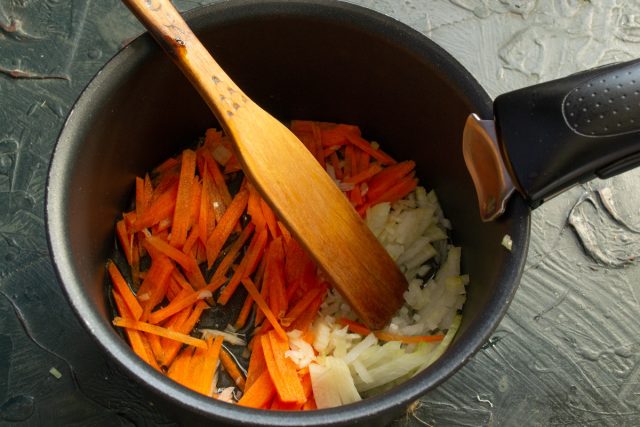 Нарезаем лук мелкими кубиками, морковь шинкуем тонкой соломкой. Разогреваем рапсовое масло в кастрюле с толстым дном и пассеруем овощи пять минут до мягкости.