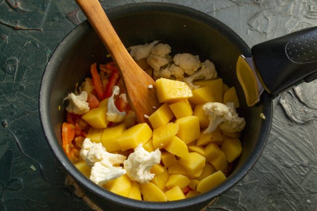 Очищаем картофель и режем кубиками. Разбираем цветную капусту на соцветия. Закладываем подготовленные овощи в кастрюлю к рыбной основе для варки супа.