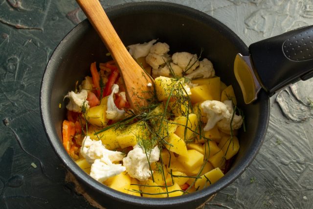 Кладем в кастрюлю веточки свежего или сушеного укропа для аромата. Эта зелень создает классическое вкусовое сочетание с белой морской рыбой и овощами.