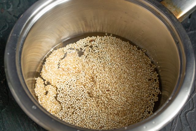 Насыпаем промытые семена киноа в сотейник и заливаем горячей водой в пропорции один к двум. Добавляем соль и доводим жидкость до активного кипения.