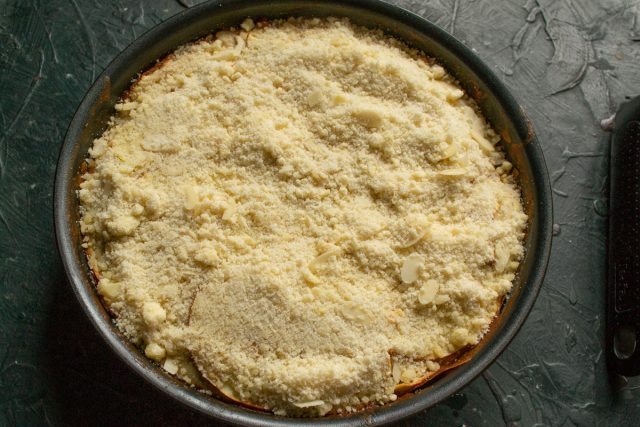 Обильно посыпаем поверхность горячего яблочного пирога подготовленным холодным миндальным штрейзелем, равномерно распределяя крошку по всей площади выпечки. Обильно посыпаем поверхность горячего яблочного пирога подготовленным холодным миндальным штрейзелем, равномерно распределяя крошку по всей площади выпечки.