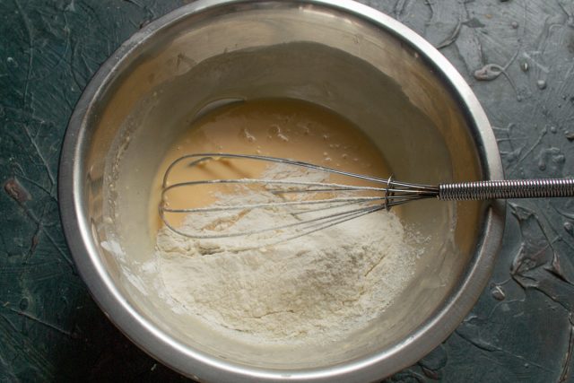 Всыпаем подготовленную смесь из муки, манной крупы и разрыхлителя в емкость с жидкой яично-молочной основой для последующего замешивания блинного теста. Всыпаем подготовленную смесь из муки, манной крупы и разрыхлителя в емкость с жидкой яично-молочной основой для последующего замешивания блинного теста.