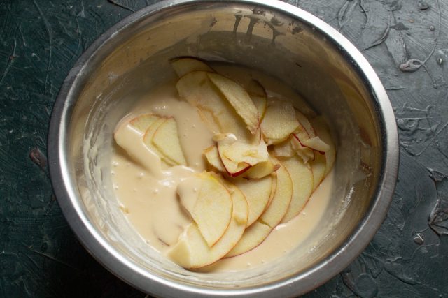 Смазываем форму для выпечки маслом и присыпаем мукой. Погружаем каждый яблочный ломтик в жидкое тесто и аккуратно выкладываем фрукты на дно подготовленной формы. Смазываем форму для выпечки маслом и присыпаем мукой. Погружаем каждый яблочный ломтик в жидкое тесто и аккуратно выкладываем фрукты на дно подготовленной формы.