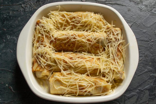 Выкладываем блины в смазанную маслом форму. Посыпаем тертым сыром и вливаем полстакана бульона, чтобы блюдо получилось сочным и мягким внутри. Выкладываем блины в смазанную маслом форму. Посыпаем тертым сыром и вливаем полстакана бульона, чтобы блюдо получилось сочным и мягким внутри.