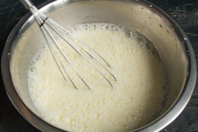 Вливаем к взбитым яйцам холодное молоко и снова тщательно перемешиваем. Жидкость можно разбавить водой или использовать сыворотку для легкости. Вливаем к взбитым яйцам холодное молоко и снова тщательно перемешиваем. Жидкость можно разбавить водой или использовать сыворотку для легкости.