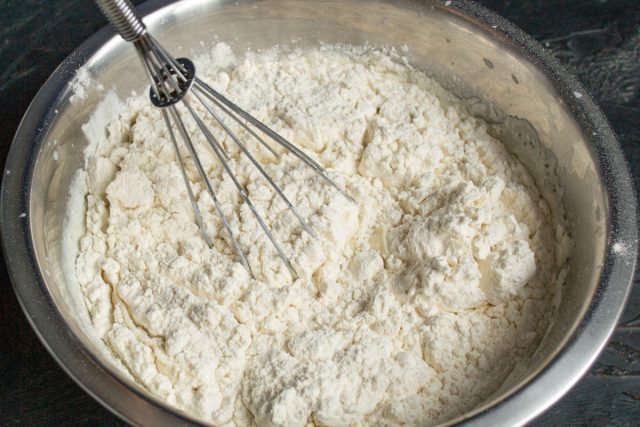 Всыпаем просеянную пшеничную муку в яично-молочную смесь. Интенсивно вымешиваем тесто венчиком, разбивая все комочки до гладкой консистенции. Всыпаем просеянную пшеничную муку в яично-молочную смесь. Интенсивно вымешиваем тесто венчиком, разбивая все комочки до гладкой консистенции.