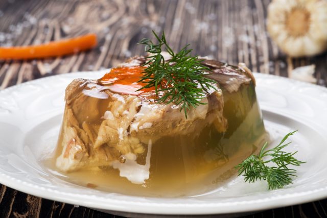 Холодец вводит иностранцев в ступор: они ждут сладкое желе, а получают застывший мясной бульон с чесноком. Но после ложки ядрёного хрена и рюмки водки «странный холодный суп» внезапно превращается в главный деликатес стола.