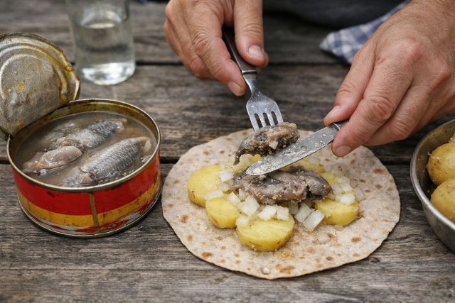 Сюрстрёмминг раскрывают на воздухе не из-за традиции, а из-за выстреливающего рассола и запаха. Сельдь кладут на тонкий хлеб с картошкой и луком — и стараются съесть быстрее, чем мозг успеет отреагировать.